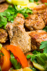 Grilled meat with vegetables on the wooden plate. Selective focus. Shallow depth of field.