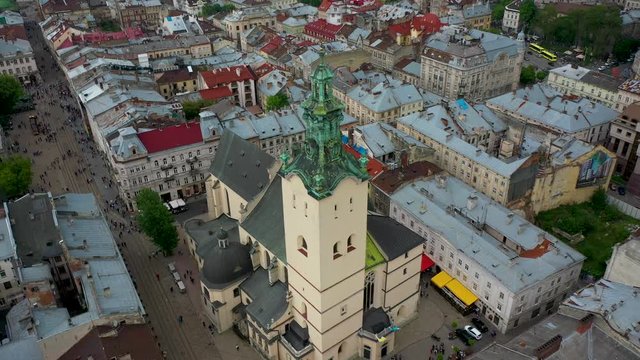 Flying near the town hall in the city of Lviv with rainy weather with clouds