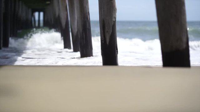 waves crashing under a pier