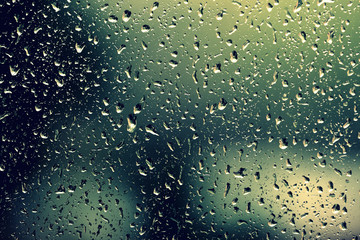 Water drops on glass during a rain close up. Natural background