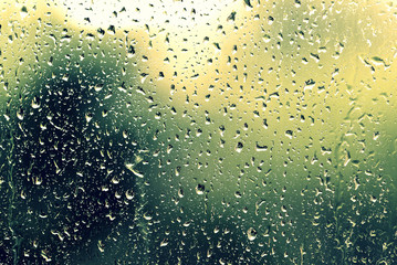 Water drops on glass during a rain close up. Natural background