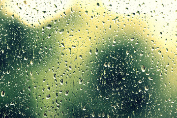 Water drops on glass during a rain close up. Natural background