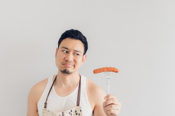 Hate face of man denied to eat sausage. Concept of hate and diet.