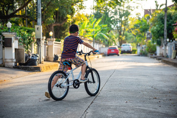 Boys ride bicycles in the village alone .