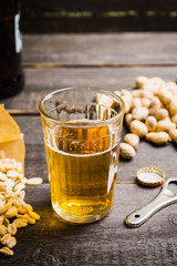 Glass of beer on the dark rustic wooden background. Selective focus. Shallow depth of field.