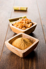 Organic Gur or Jggery Powder is unrefined sugar obtained from concentrated sugarcane juice. served in a bowl. selective focus