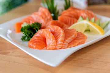 Fresh salmon sashimi sliced in white dish.