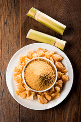 Organic Gur or Jggery Powder is unrefined sugar obtained from concentrated sugarcane juice. served in a bowl. selective focus