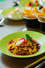 Farfalle pasta in a green plate.