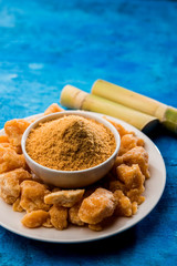 Organic Gur or Jggery Powder is unrefined sugar obtained from concentrated sugarcane juice. served in a bowl. selective focus