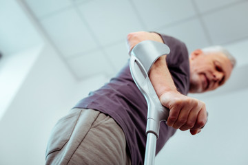 Selective focus of a male hand holding crutches