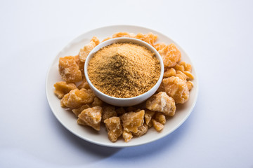 Organic Gur or Jggery Powder is unrefined sugar obtained from concentrated sugarcane juice. served in a bowl. selective focus