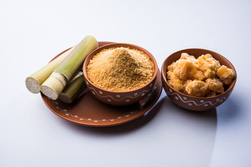 Organic Gur or Jggery Powder is unrefined sugar obtained from concentrated sugarcane juice. served in a bowl. selective focus