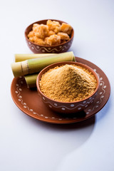 Organic Gur or Jggery Powder is unrefined sugar obtained from concentrated sugarcane juice. served in a bowl. selective focus