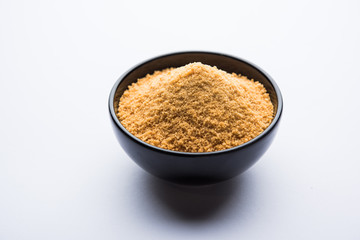 Organic Gur or Jggery Powder is unrefined sugar obtained from concentrated sugarcane juice. served in a bowl. selective focus