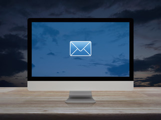 email flat icon on desktop modern computer monitor screen on wooden table over sunset sky, Business...