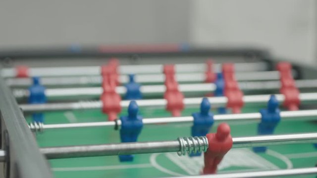 Two business partners have a leisure time together and play table football outside of office. 