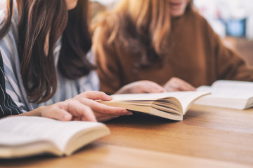 Group of young people sitting and enjoyed reading books together on wooden table