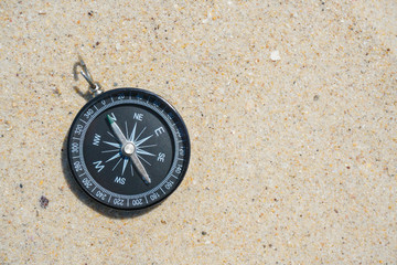 black compass on the beach sand