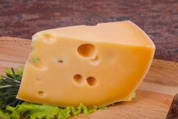 Maasdam cheese  in the board served salad leaves