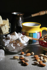 A mug of coffee and different oriental sweets: turkish delight, halva, almond and pistachio