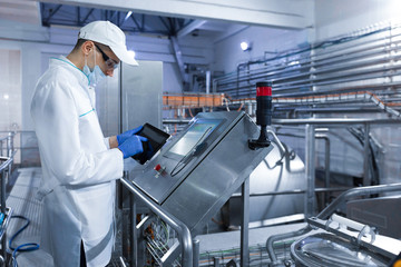 man in a white robe and a cap make a configure the digital screen