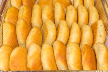 Freshly baked Buttered Dinner Rolls:  Freshly baked buttered dinner rolls in a pan ready to be served at a restaurant deli. 