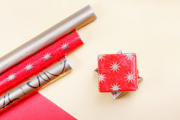 Golden gift boxes and red wrapping paper on bright background