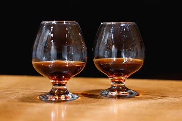 Two goblets of brandy on wooden old counter top