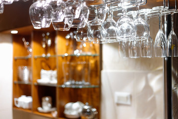 Empty  glasses hanging above the bar in the restaurant.