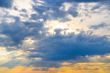 evening sky with blue clouds and sun rays, beautiful sky at sunset. the combination of yellow and blue in nature