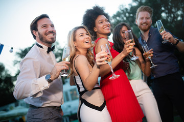 Group of happy friends partying and toasting drinks