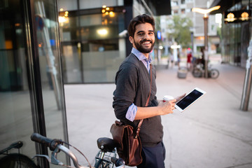 Portrait of young businessman holding tablet outdoor