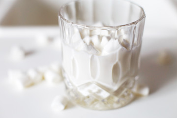 marshmallow in a glass of milk. marshmallows on a white background