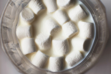 marshmallow in a glass of milk. marshmallows on a white background