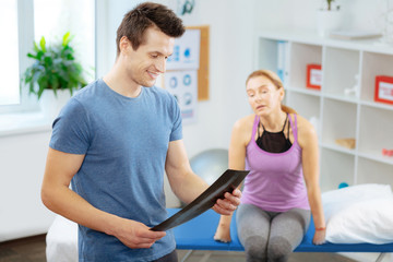 Positive joyful doctor looking at the X ray image