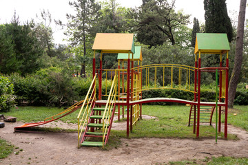 Fototapeta na wymiar Iron multi colored playground on in the park. In harmony with nature eco-Playground for children