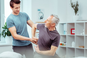 Obraz premium Pleasant senior man showing a painful place