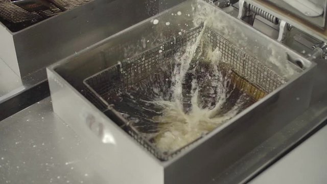 Fresh raw chicken breast dropped into boiling oil. Slow Motion