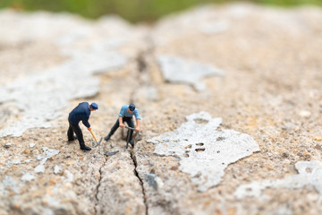 Miniature people : Worker team working on  concrete with cracked , Team work  concept