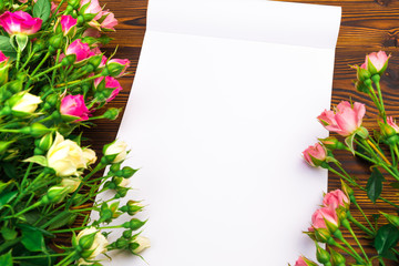 bouquet of small colored roses on a wooden  background with white album sheet  - Image