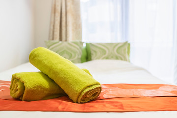 Rolled towels placed on the bed in the bedroom