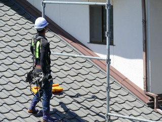 屋根の上で作業をする男