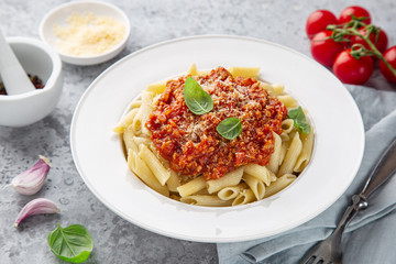 penne pasta with Bolognese sause and parmesan cheese in white plate
