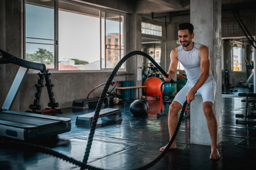 Young handsome man doing exercises in gym.