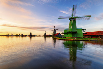 Fototapeta na wymiar Dutch landscape with windmill at dramatic sunset, Zaandam, Amsterdam, Netherlands