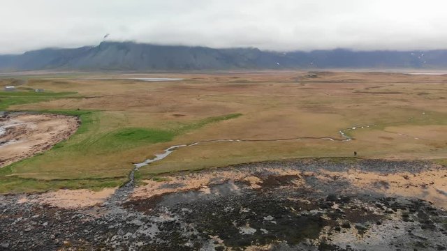 Aerial video of Ytri Tunga beach in Iceland. Moving towards the land and showing mountains with clouds in the background.
