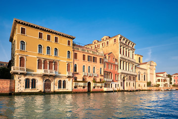 Fototapeta na wymiar Old houses by Grand Canal in Venice, Italy, on a bright day