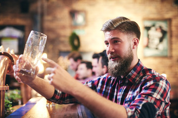 Handsome man ordering one beer in the pub