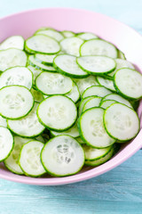 cucumbers in a bowl on turquoise surface